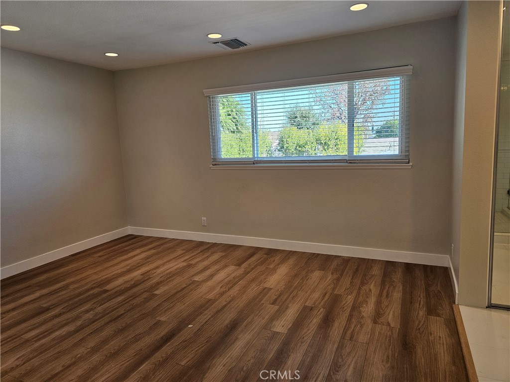 4068 Av. Sevilla Cypress, CA 90630 - Photo 11 of 17 an empty room with wooden floor and windows
