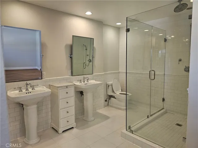 a bathroom with a sink mirror and shower