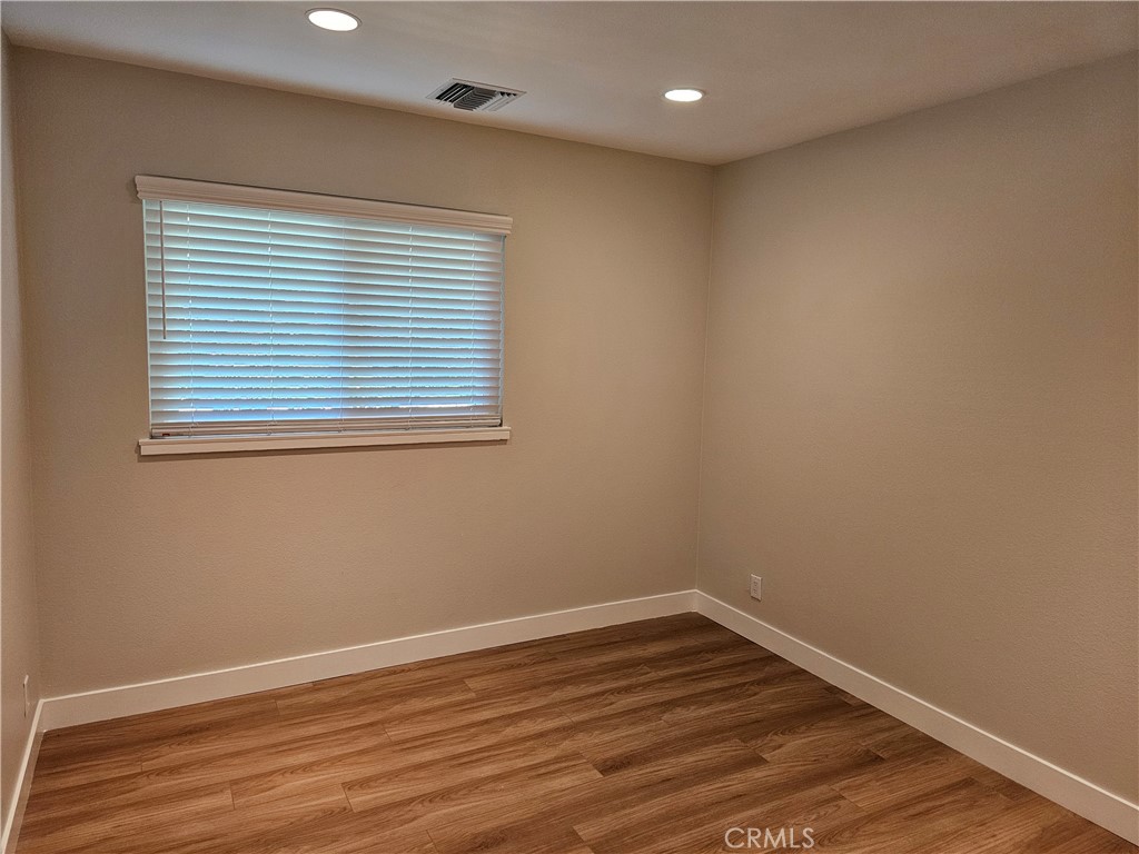 4068 Av. Sevilla Cypress, CA 90630 - Photo 13 of 17 a view of an empty room with wooden floor and a window