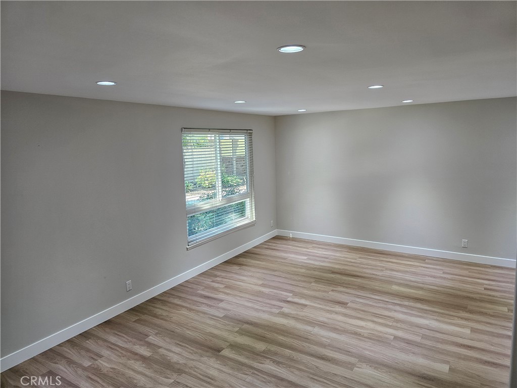 4068 Av. Sevilla Cypress, CA 90630 - Photo 4 of 17 an empty room with wooden floor and windows