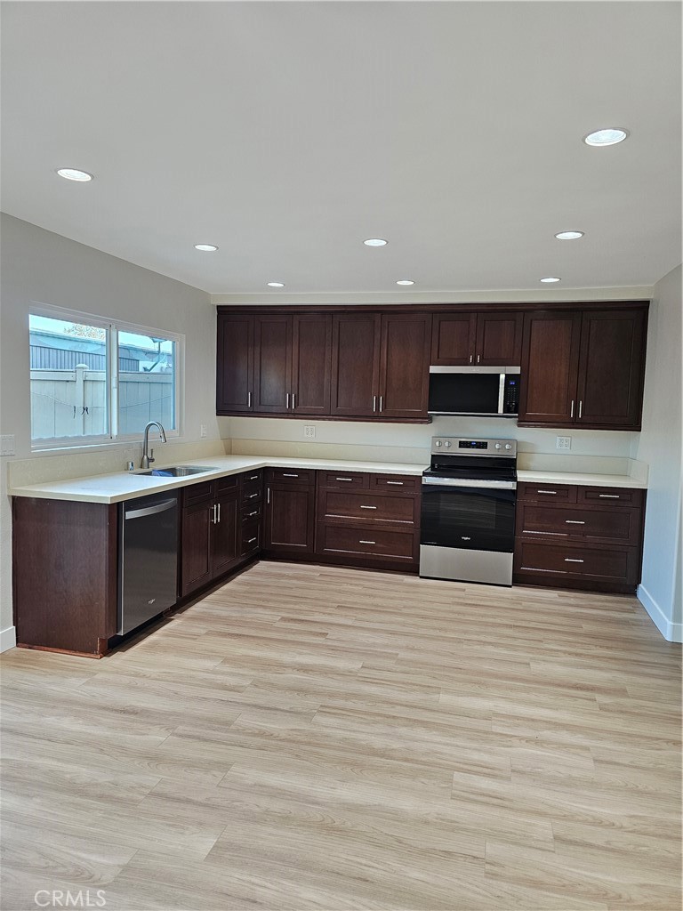 4068 Av. Sevilla Cypress, CA 90630 - Photo 8 of 17 a large kitchen with stainless steel appliances and a sink