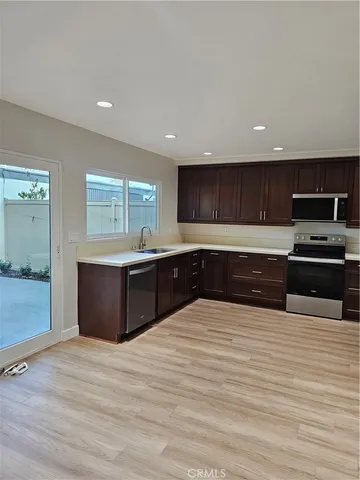 a large kitchen with wooden floors and stainless steel appliances