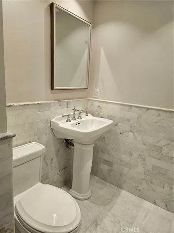 a white toilet sitting next to a bathroom sink