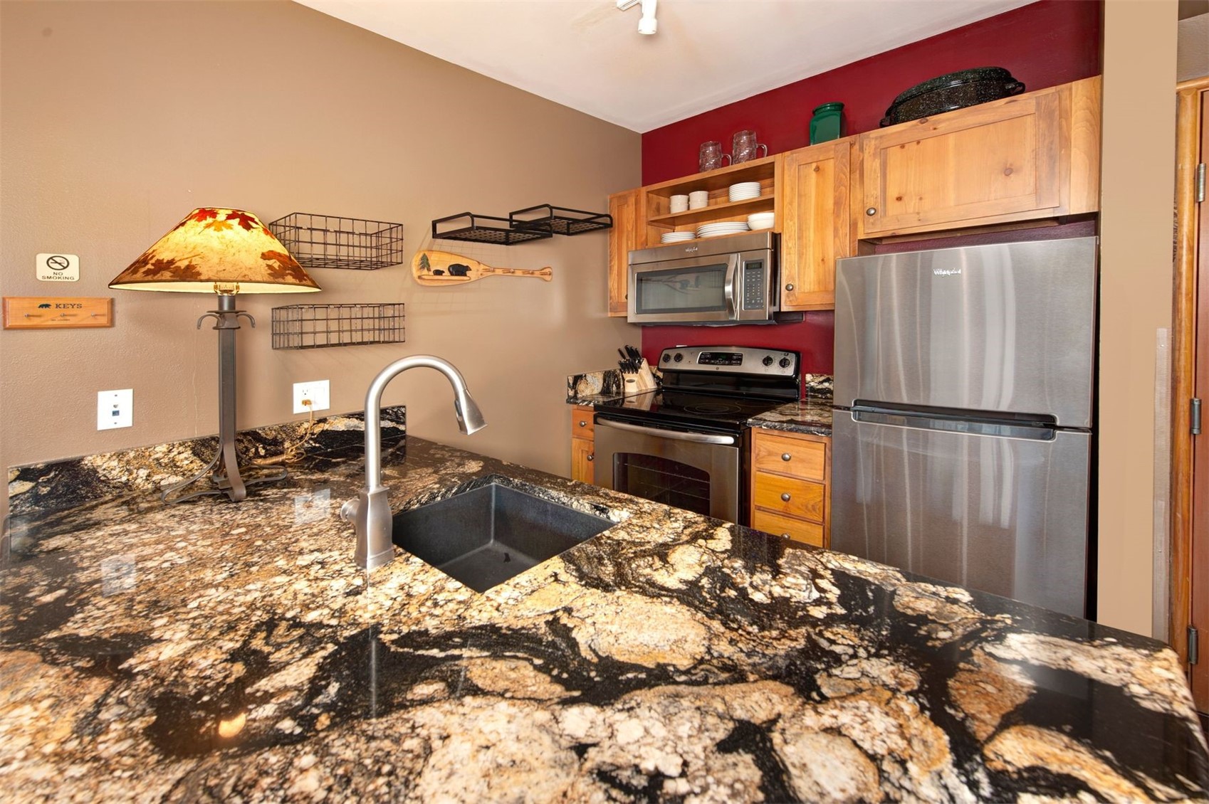 129 River Run Road, Unit 8040 Keystone, CO 80435 - Photo 5 of 50 Kitchen featuring appliances with stainless steel finishes, a sink, open shelves, and dark stone counters