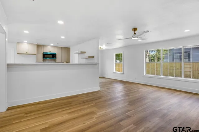 wooden floor in an empty room with a kitchen