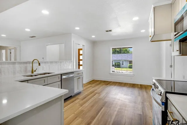 a view of a kitchen with a sink wooden floor and a window