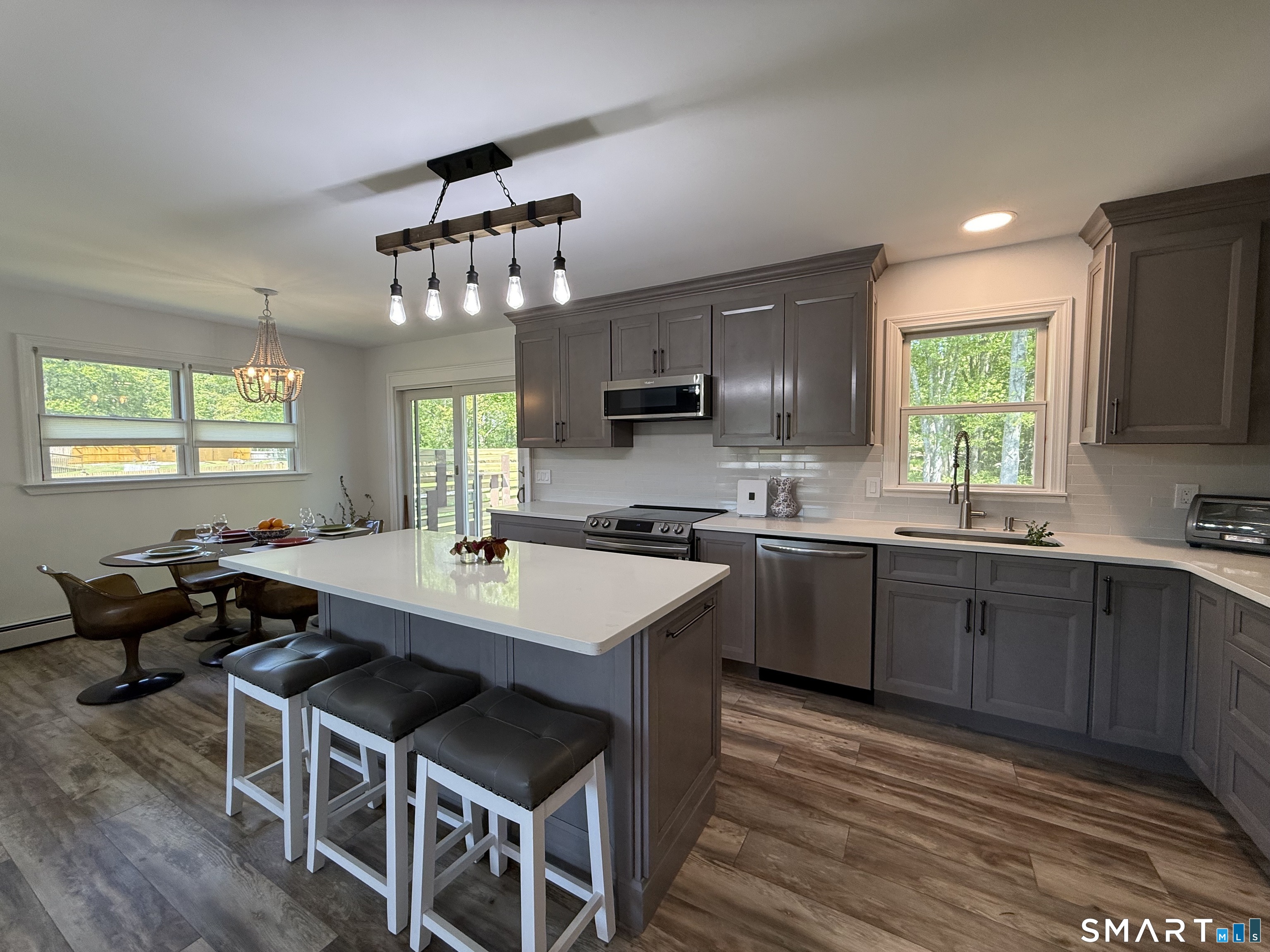 29 Deer Ridge Road Stonington, CT 06378 - Photo 26 of 35 a kitchen with a dining table chairs sink and cabinets
