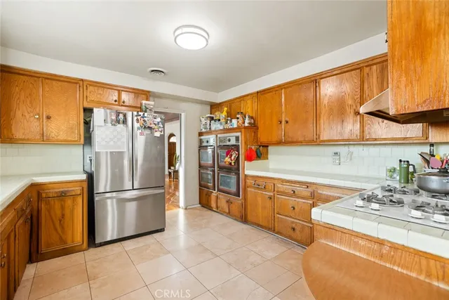 a kitchen with stainless steel appliances granite countertop a refrigerator and a sink