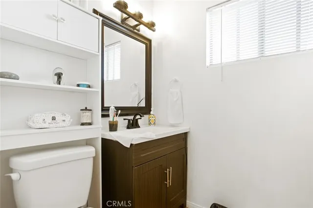 a bathroom with a sink a toilet and a mirror