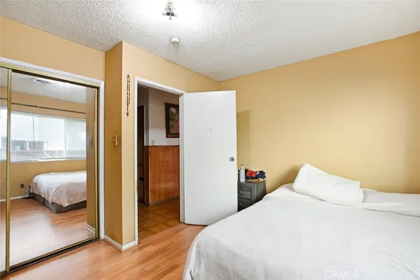 a bedroom with a bed and wooden floor