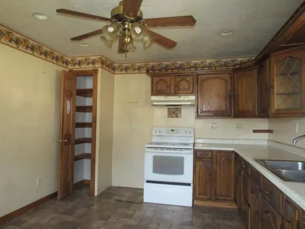 a kitchen that has a sink a stove and cabinets