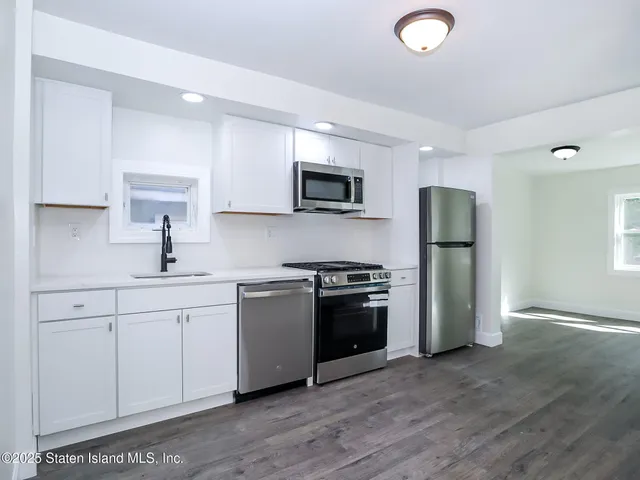 a kitchen with stainless steel appliances granite countertop a refrigerator sink and stove
