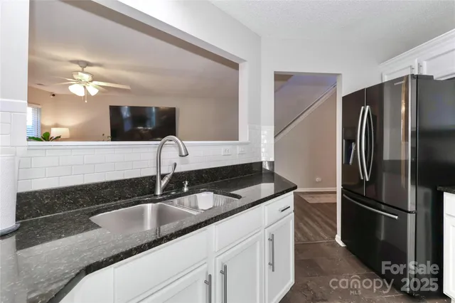 a kitchen with stainless steel appliances granite countertop a sink and a refrigerator