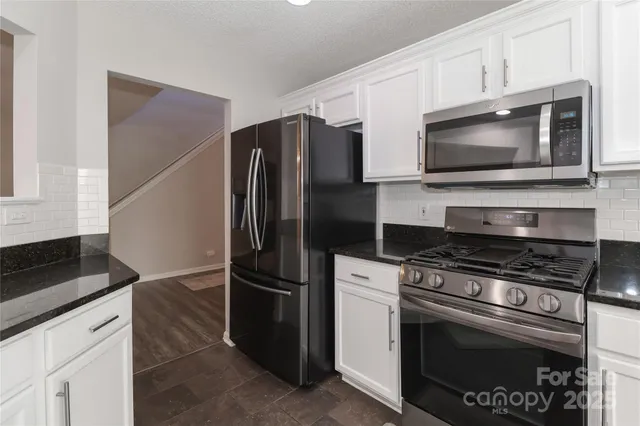 a kitchen with cabinets stainless steel appliances and a counter space
