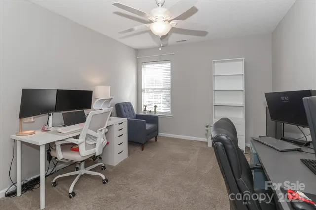 a living room with furniture a flat screen tv and a window