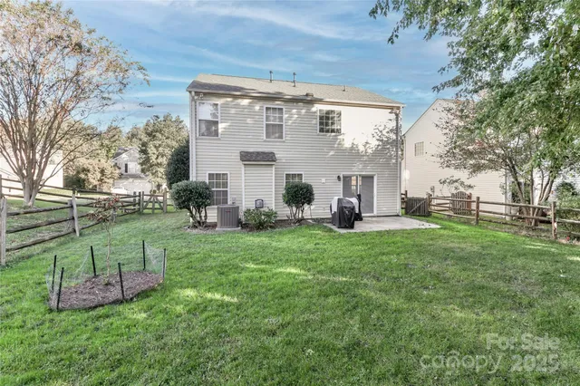 a view of a house with backyard and a tree