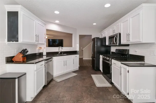 a kitchen with stainless steel appliances kitchen island granite countertop a sink and cabinets