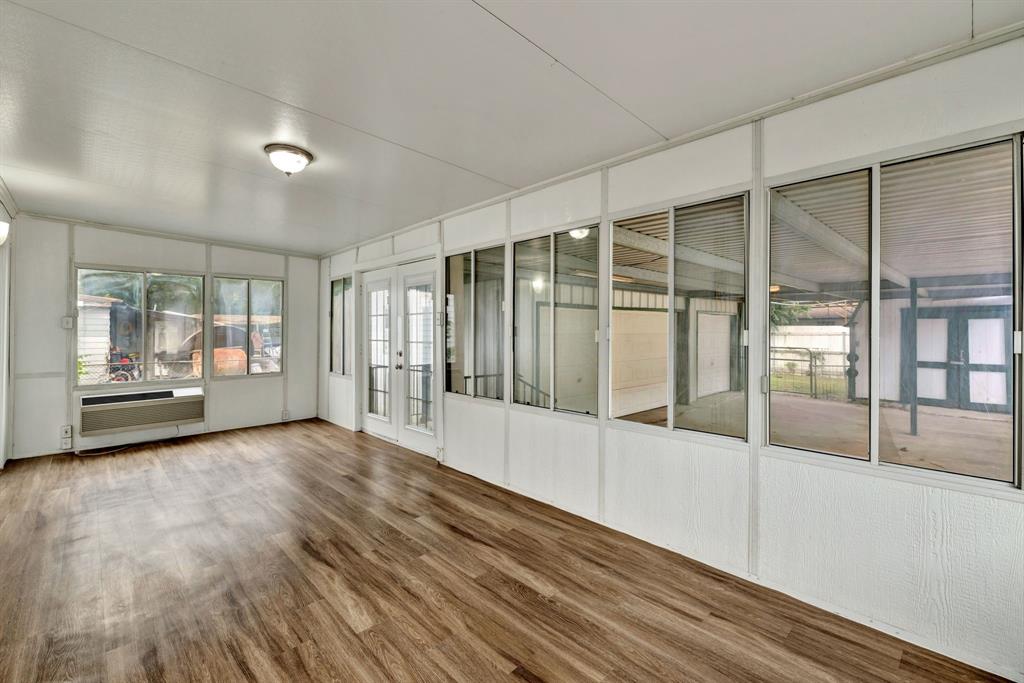 613 Cheyenne Road Dallas, TX 75217 - Photo 23 of 28 Enclosed sunroom featuring wood-finish flooring, white panel walls, multiple windows, and a double-door entry