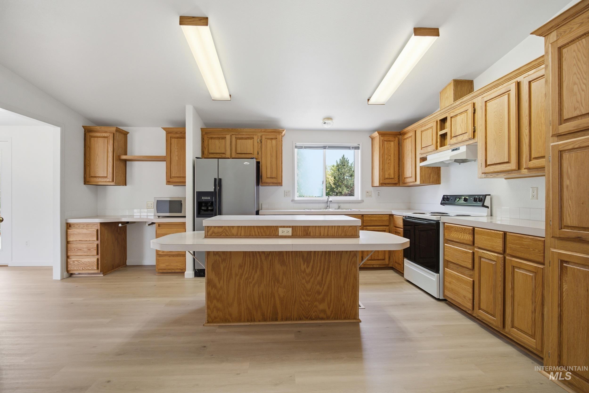 7422 Track Road Nampa, ID 83686 - Photo 5 of 50 Spacious kitchen featuring extensive wood cabinetry, light-toned countertops, and light wood-finish flooring