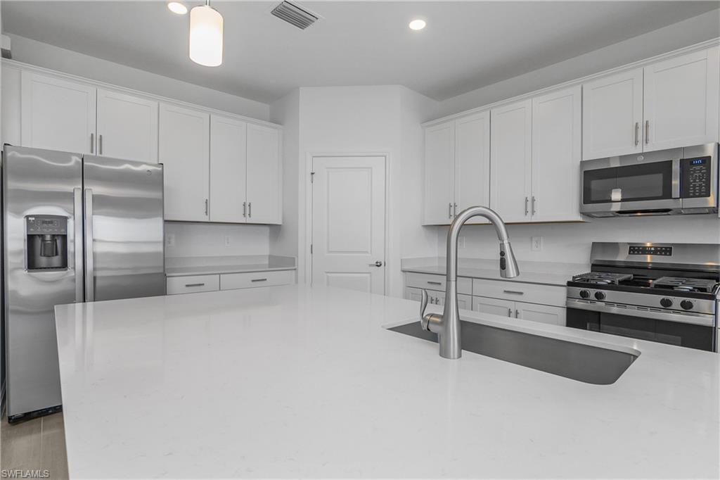 21094 Verawood Loop Estero, FL 33928 - Photo 12 of 49 a kitchen with stainless steel appliances granite countertop a stove a sink and a refrigerator