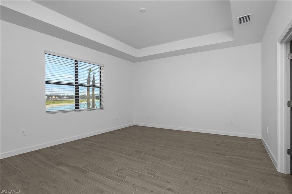 21094 Verawood Loop Estero, FL 33928 - Photo 25 of 49 an empty room with wooden floor and windows