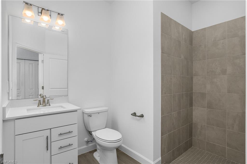 21094 Verawood Loop Estero, FL 33928 - Photo 30 of 49 a bathroom with a toilet sink vanity and mirror