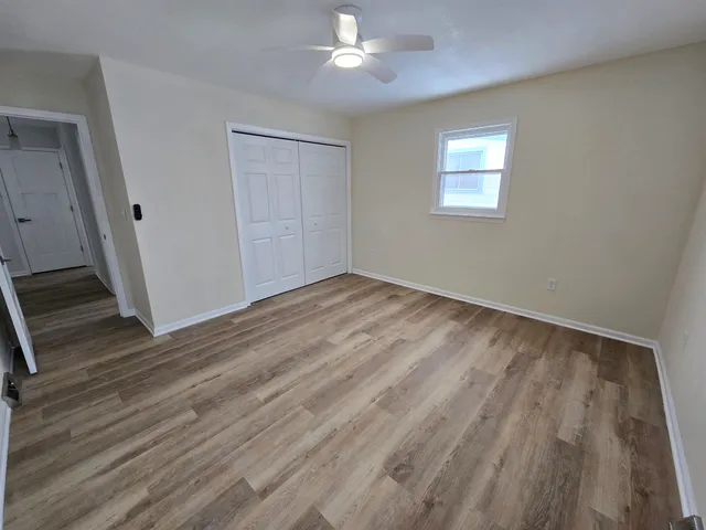 a view of empty room with wooden floor