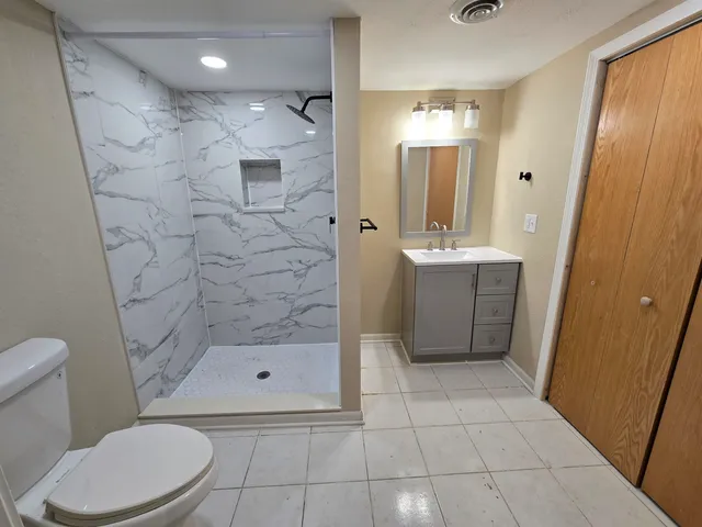 a bathroom with a sink a toilet and shower