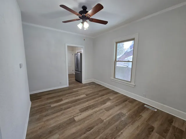 an empty room with windows and fan