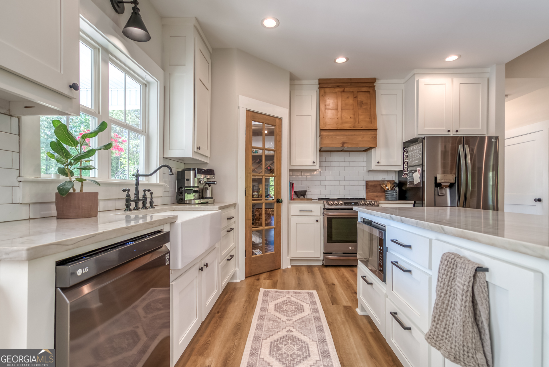 1281 Chilton Woods Road Rutledge, GA 30663 - Photo 16 of 59 a kitchen with white cabinets and stainless steel appliances