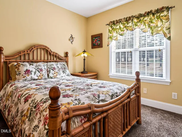 a bed sitting in a bedroom next to a window