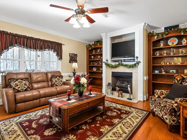 a living room with furniture a flat screen tv and a fireplace