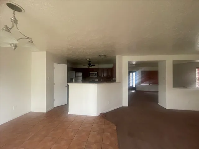 a view of a hallway with an empty room and fire place