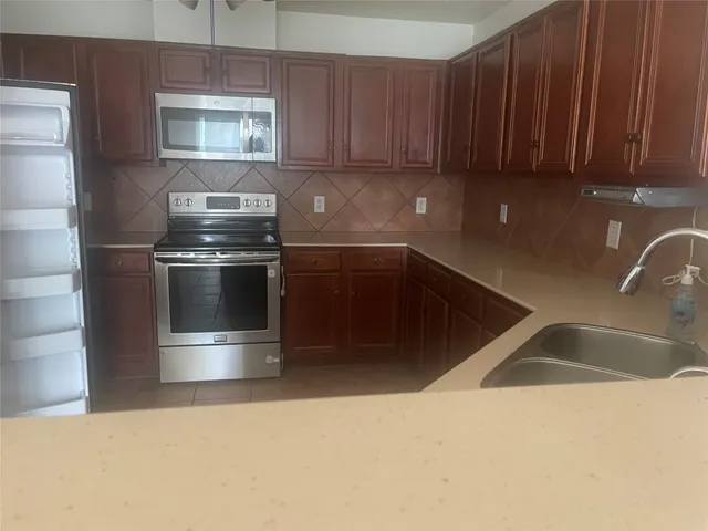 a kitchen with stainless steel appliances granite countertop a sink and a stove