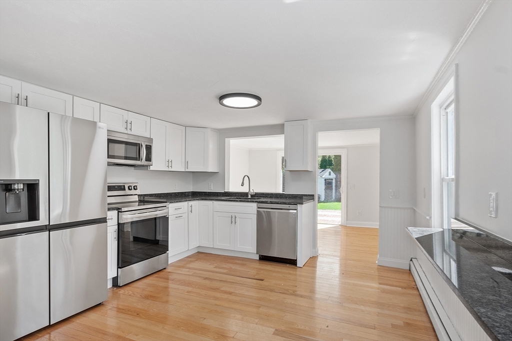 43 Public Road Lancaster, MA 01523 - Photo 4 of 31 a kitchen with granite countertop stainless steel appliances and wooden cabinets