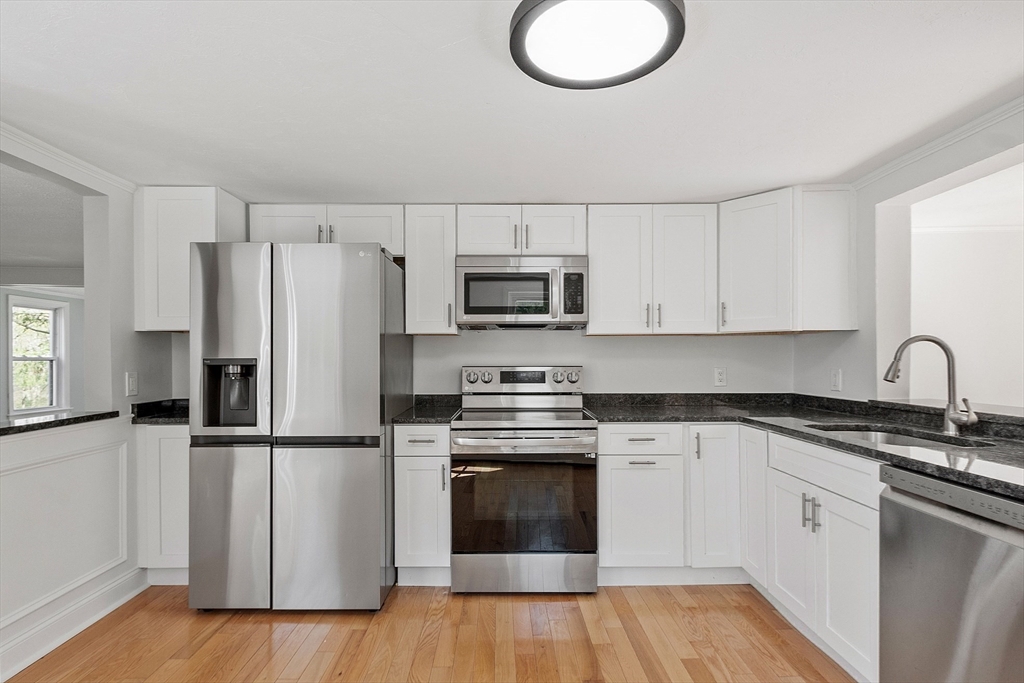 43 Public Road Lancaster, MA 01523 - Photo 5 of 31 a kitchen with cabinets stainless steel appliances and wooden floor