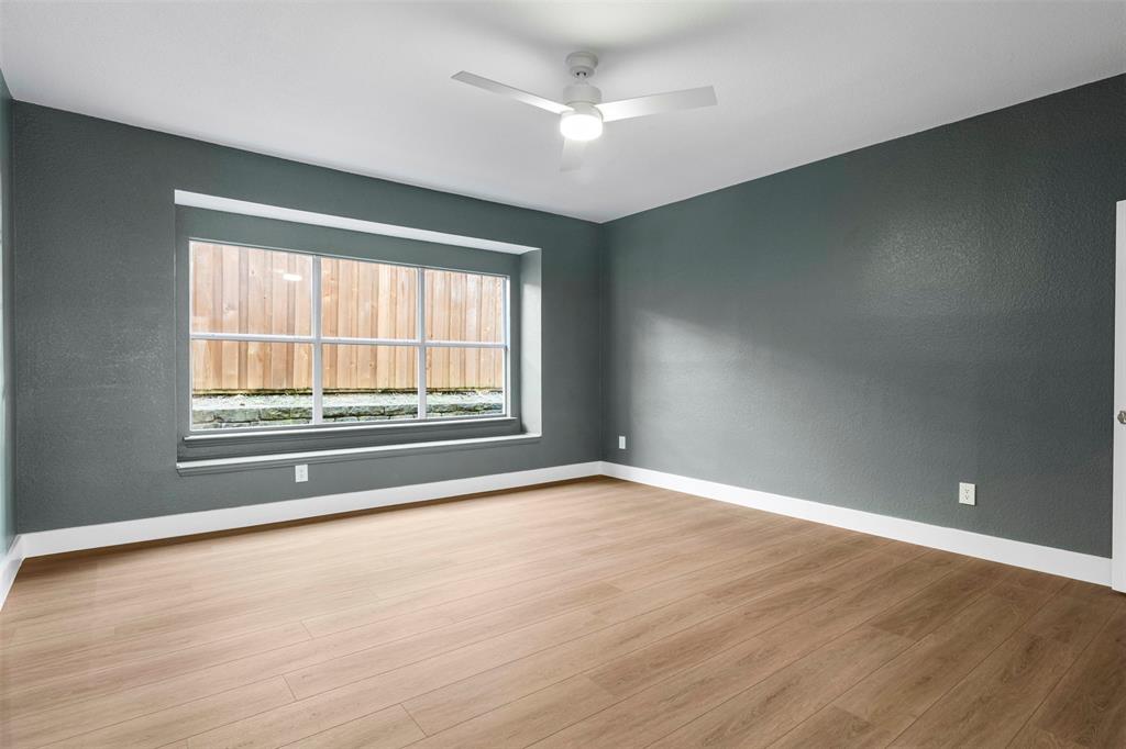 421 Ridge Meade Drive Lewisville, TX 75067 - Photo 11 of 36 an empty room with wooden floor and windows