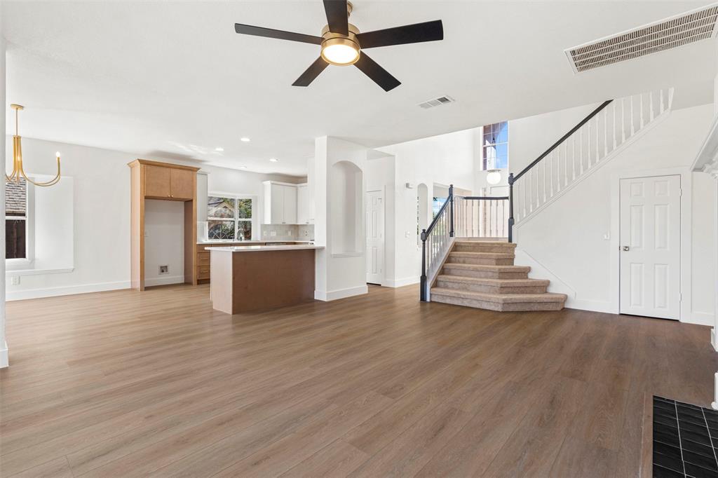 421 Ridge Meade Drive Lewisville, TX 75067 - Photo 14 of 36 a view of a livingroom with wooden floor and a ceiling fan