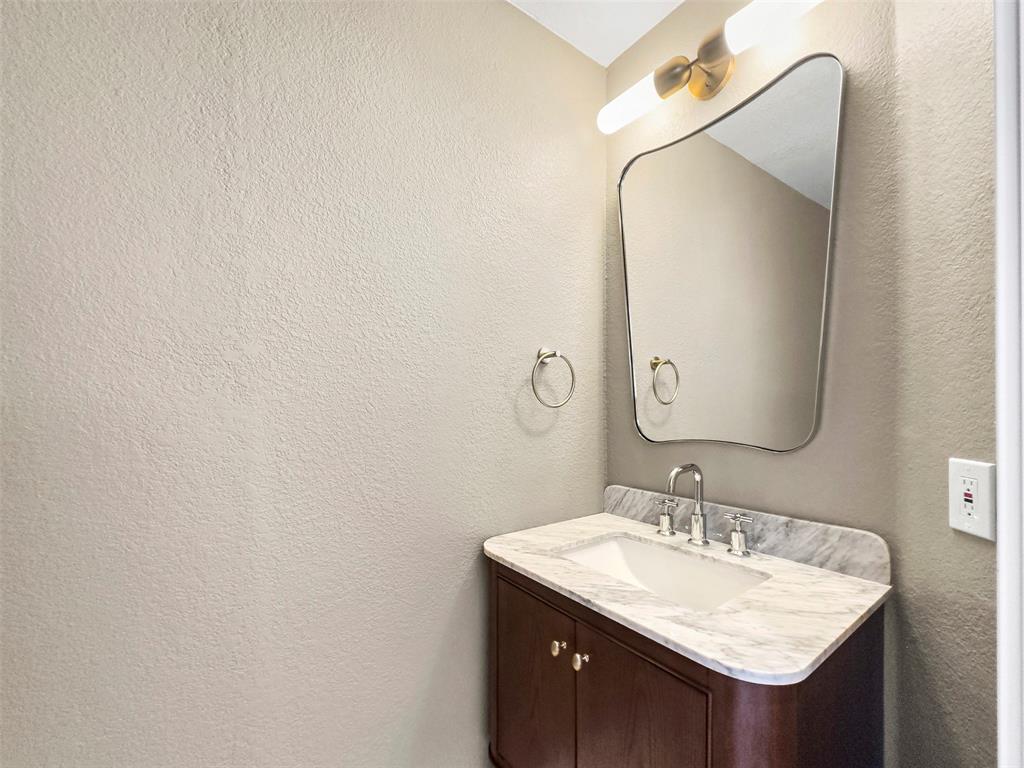 421 Ridge Meade Drive Lewisville, TX 75067 - Photo 27 of 36 a bathroom with a granite countertop sink and a mirror