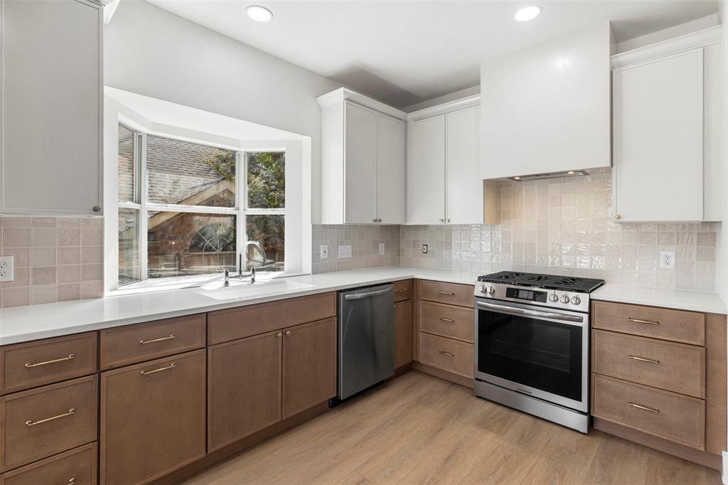 421 Ridge Meade Drive Lewisville, TX 75067 - Photo 4 of 36 a kitchen with sink stove and cabinets