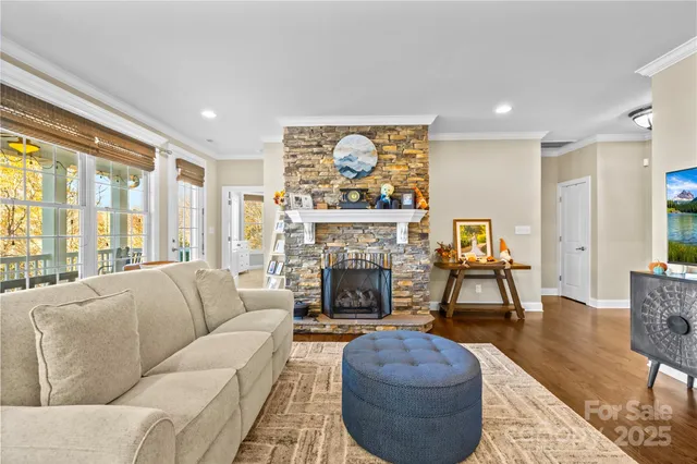 a living room with furniture a fireplace and a large window
