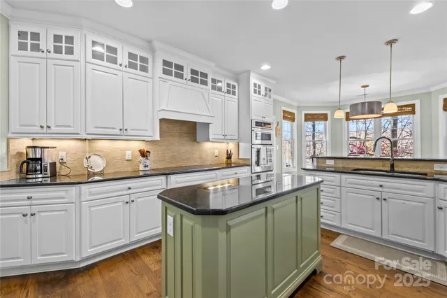 a kitchen with granite countertop a sink a stove and cabinets