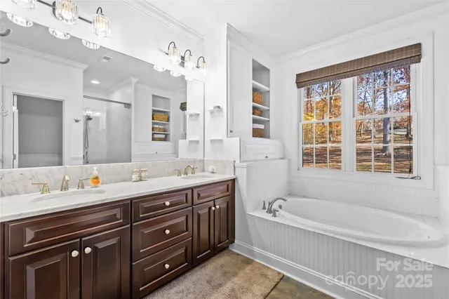 a spacious bathroom with a tub sink shower and mirror
