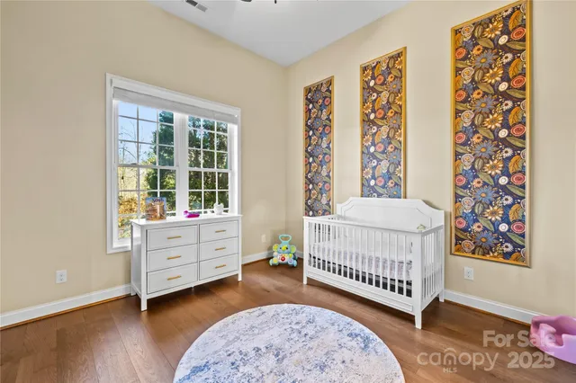 a bedroom with a baby bed a couch and a window