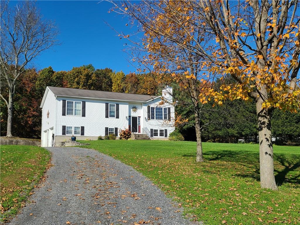 a front view of a house with a yard and trees
