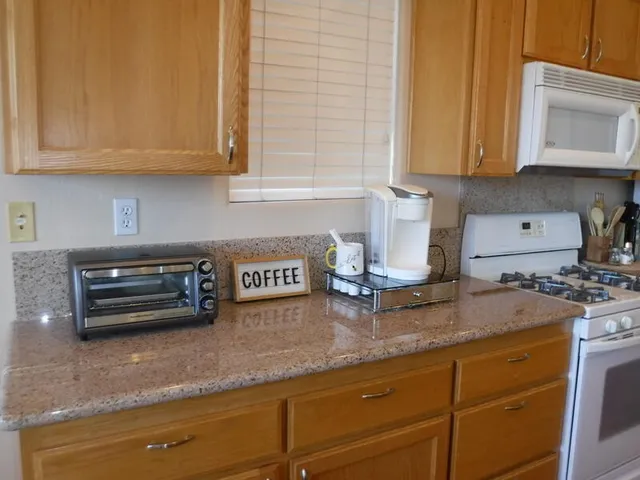 a kitchen with stainless steel appliances granite countertop a sink a stove and a refrigerator