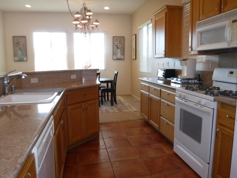 49544 Wayne Street Indio, CA 92201 - Photo 19 of 69 a kitchen with stainless steel appliances granite countertop a sink a stove and a refrigerator