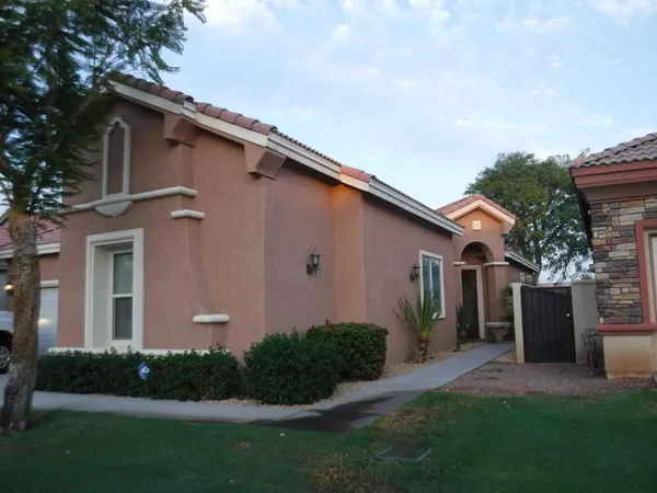 a front view of a house with a garden and plants