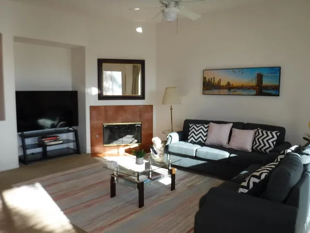 a view of a workspace with furniture and a window