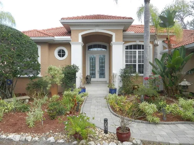 a view of a house with a yard and large tree